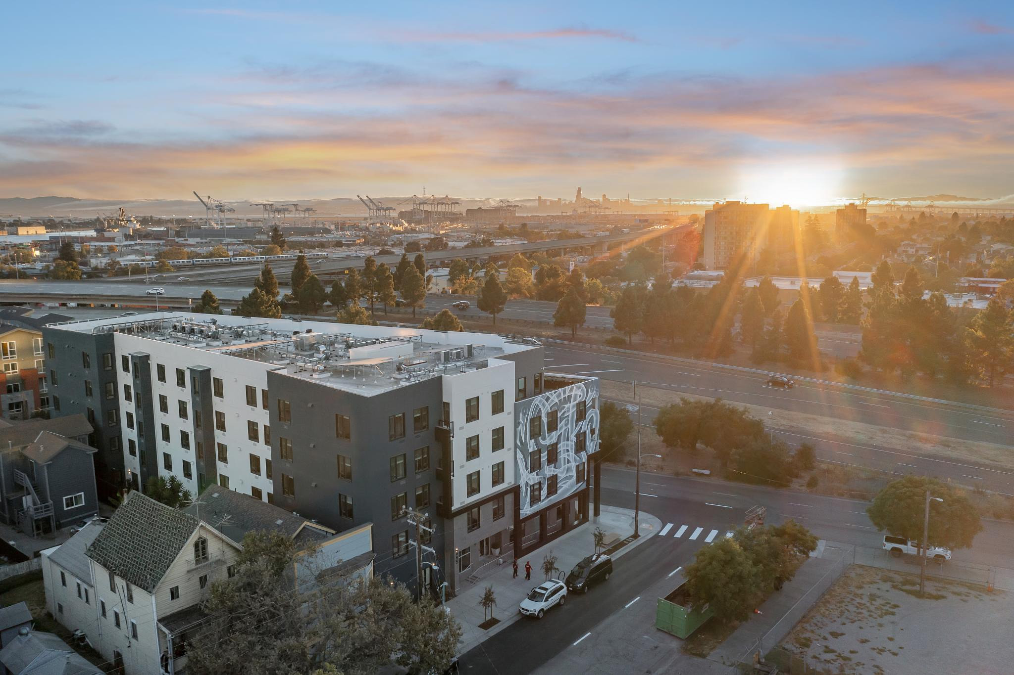 Aerial view of a dense, well-planned urban neighborhood with mixed-use buildings, green spaces, and efficient transportation infrastructure.